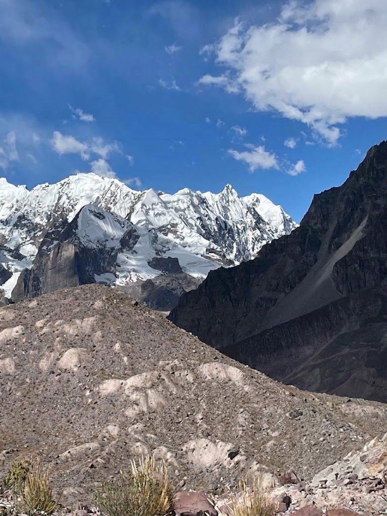 Cumbres nevadas de los Andes sobre una ladera de piedra bajo cielo azul